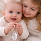 children holding a teardrop handprint keyring