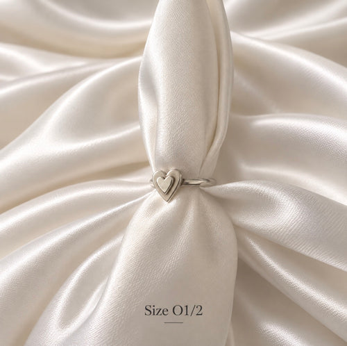 Silver ring with two hearts on top of each oither