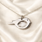 Fingerprint on a silver bird necklace
