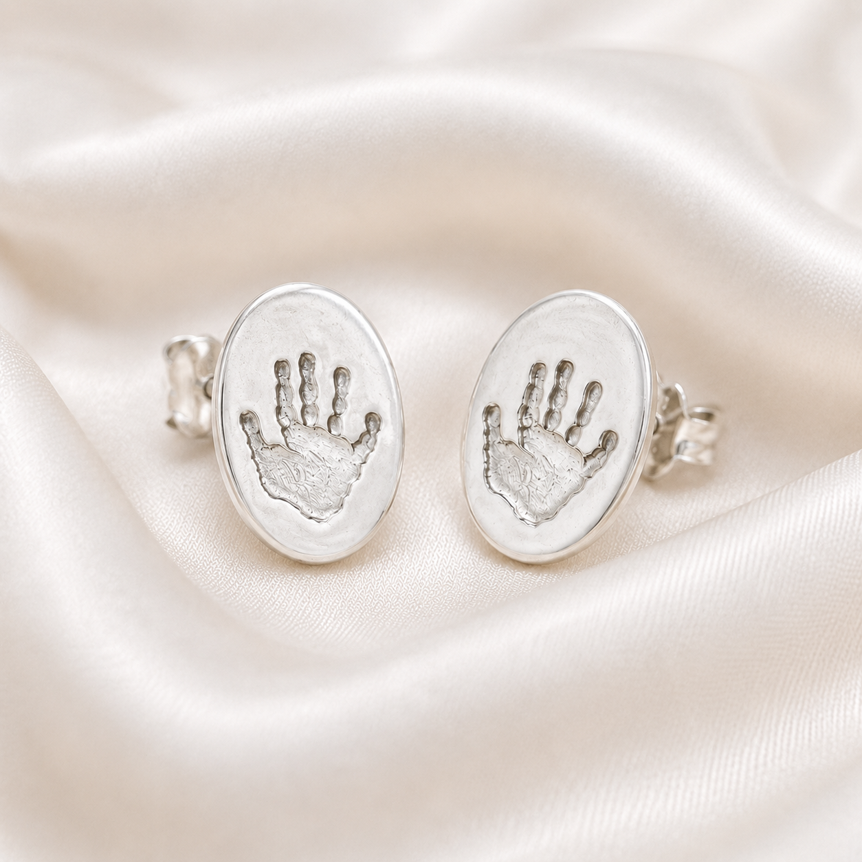 Handprints on silver oval studs