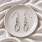 Oval silver drop down earrings with a hammer effect