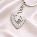 plectrum shaped silver keyring with child's handprint on it