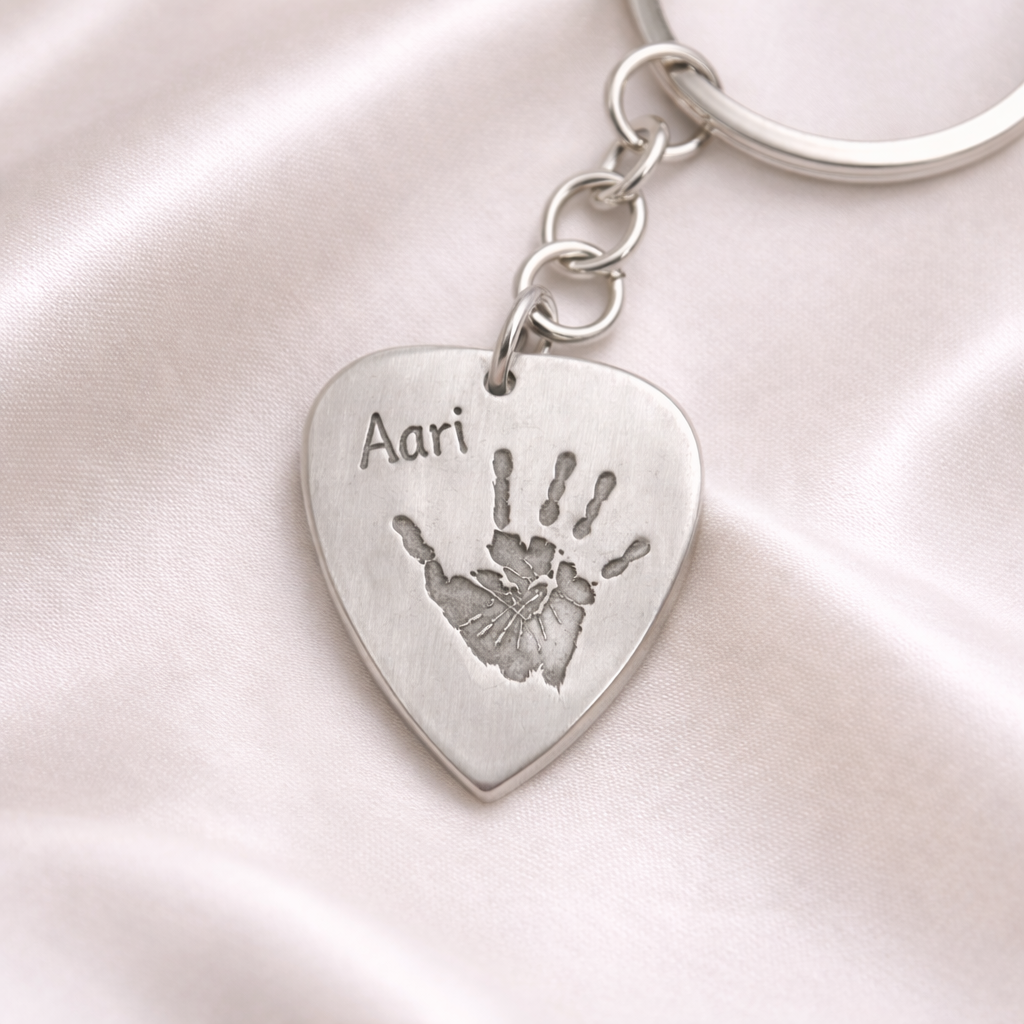 plectrum shaped silver keyring with child's handprint on it