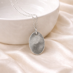 Fingerprint on a silver oval pendant