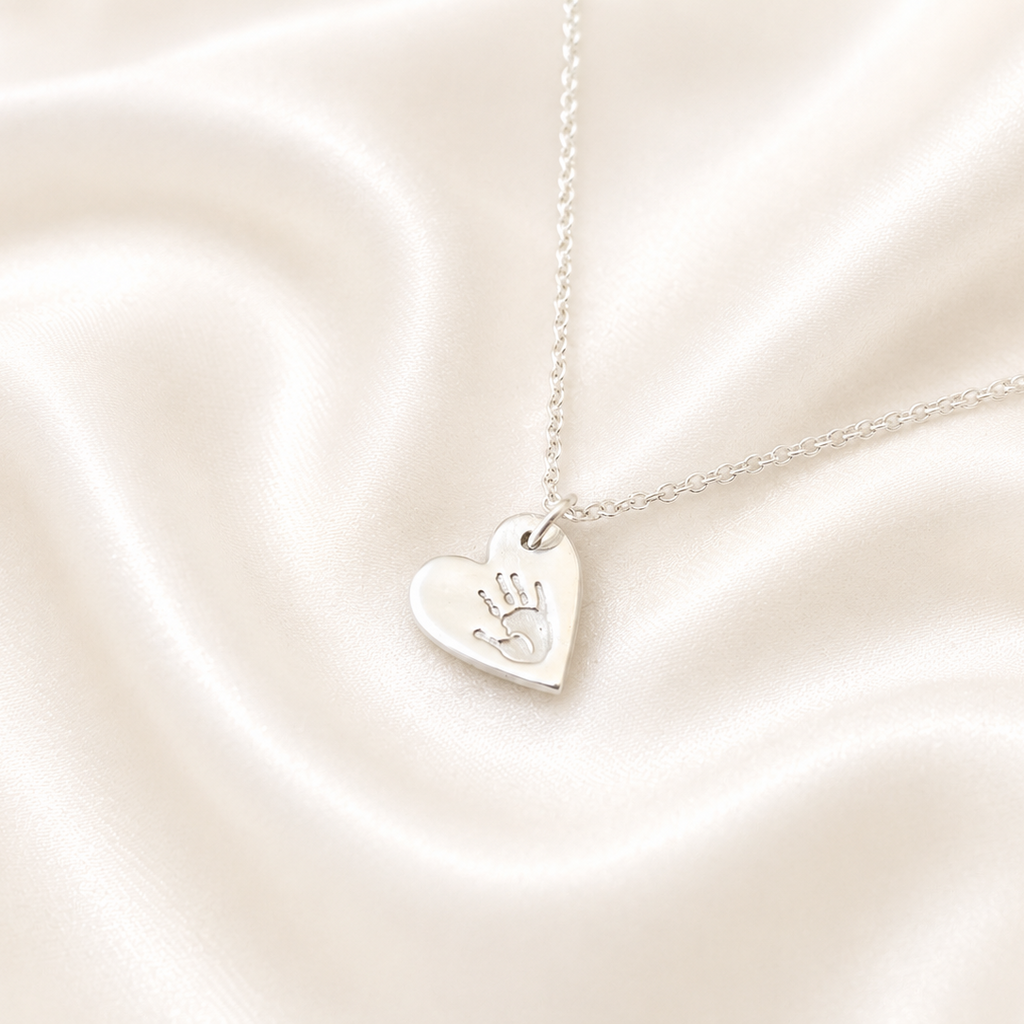 handprint on a silver small heart