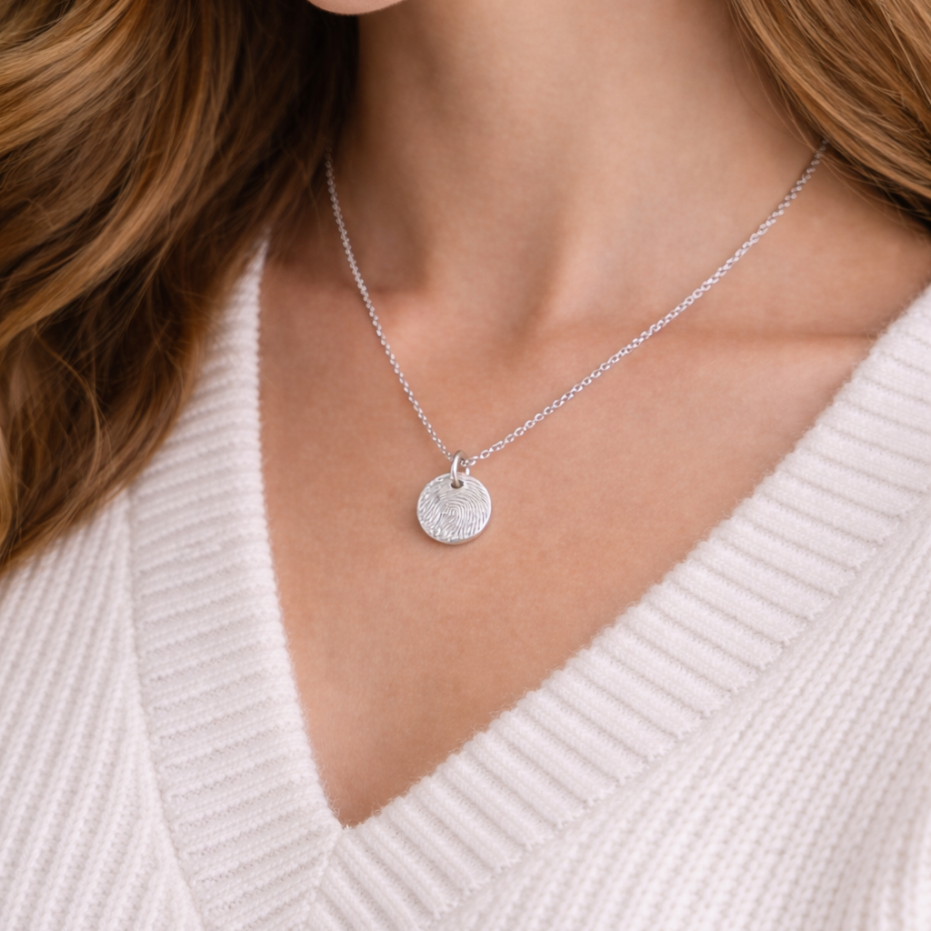 Fingerprint on a circle silver pendant on a woman