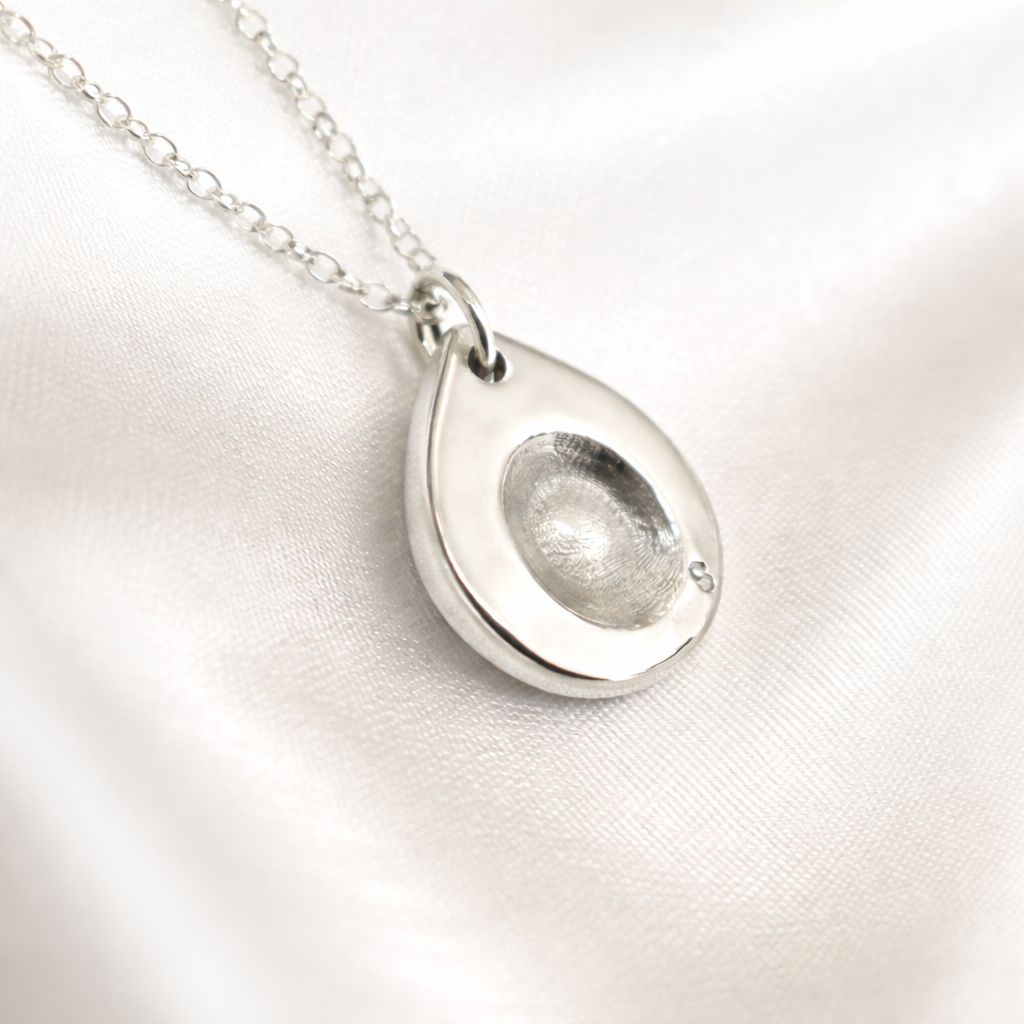 small fingerprint on silver pendant