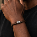 handprint on a silver charm on a leather bracelet