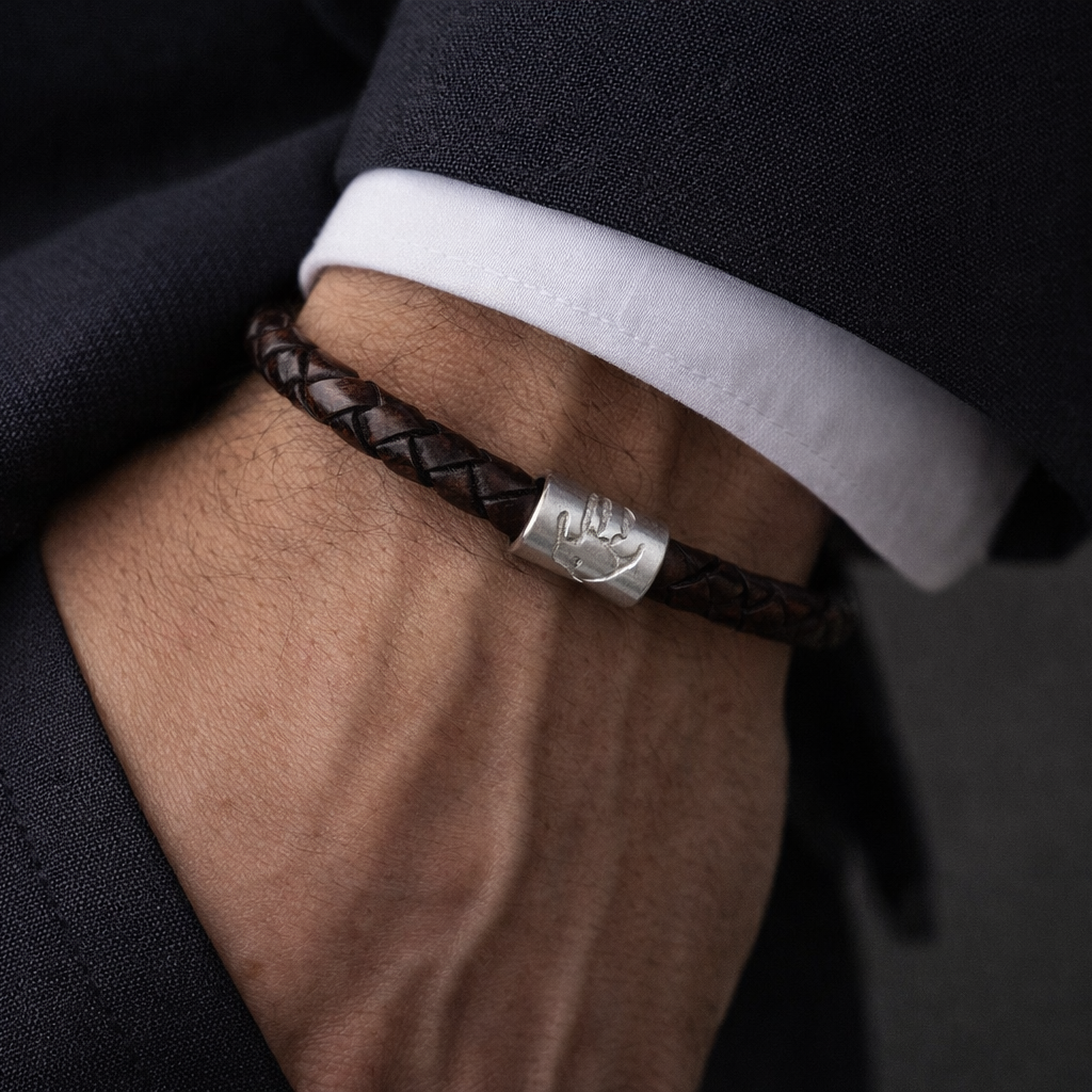 handprint on a charm on a leather bracelet
