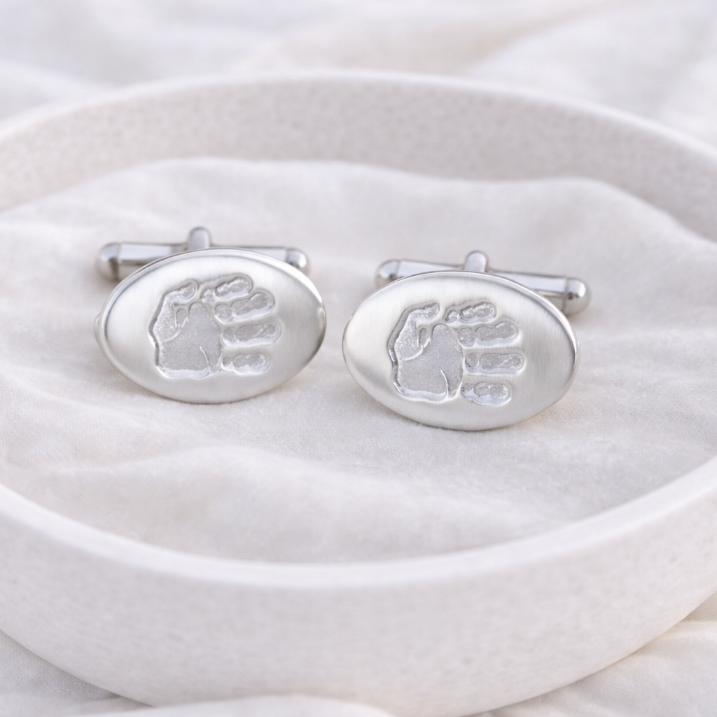 Silver oval cufflinks with personalised prints on them