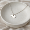 little silver bird necklace with hidden cremation ashes in it.