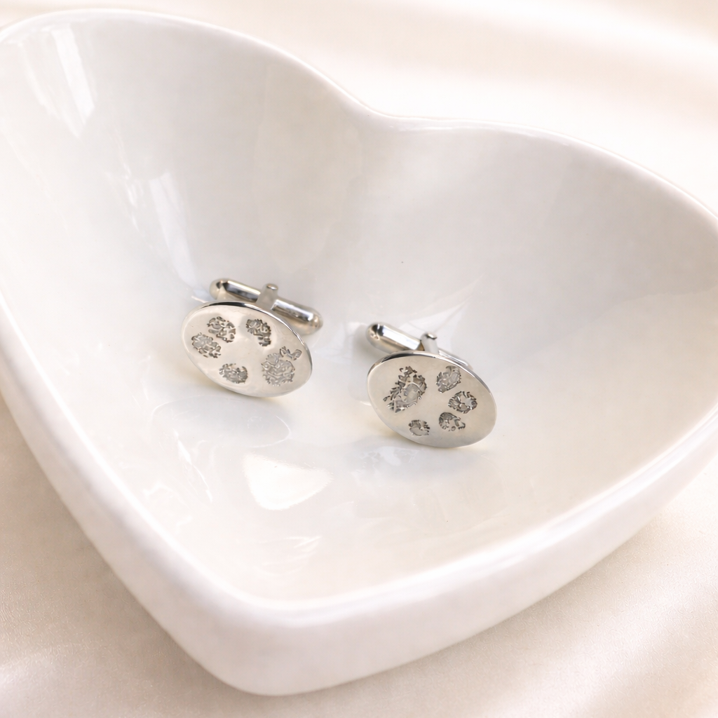 Silver oval cufflinks with personalised pawprints on them.
