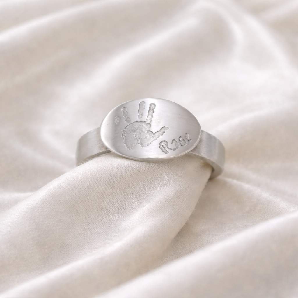 Ring with handprint on it and name