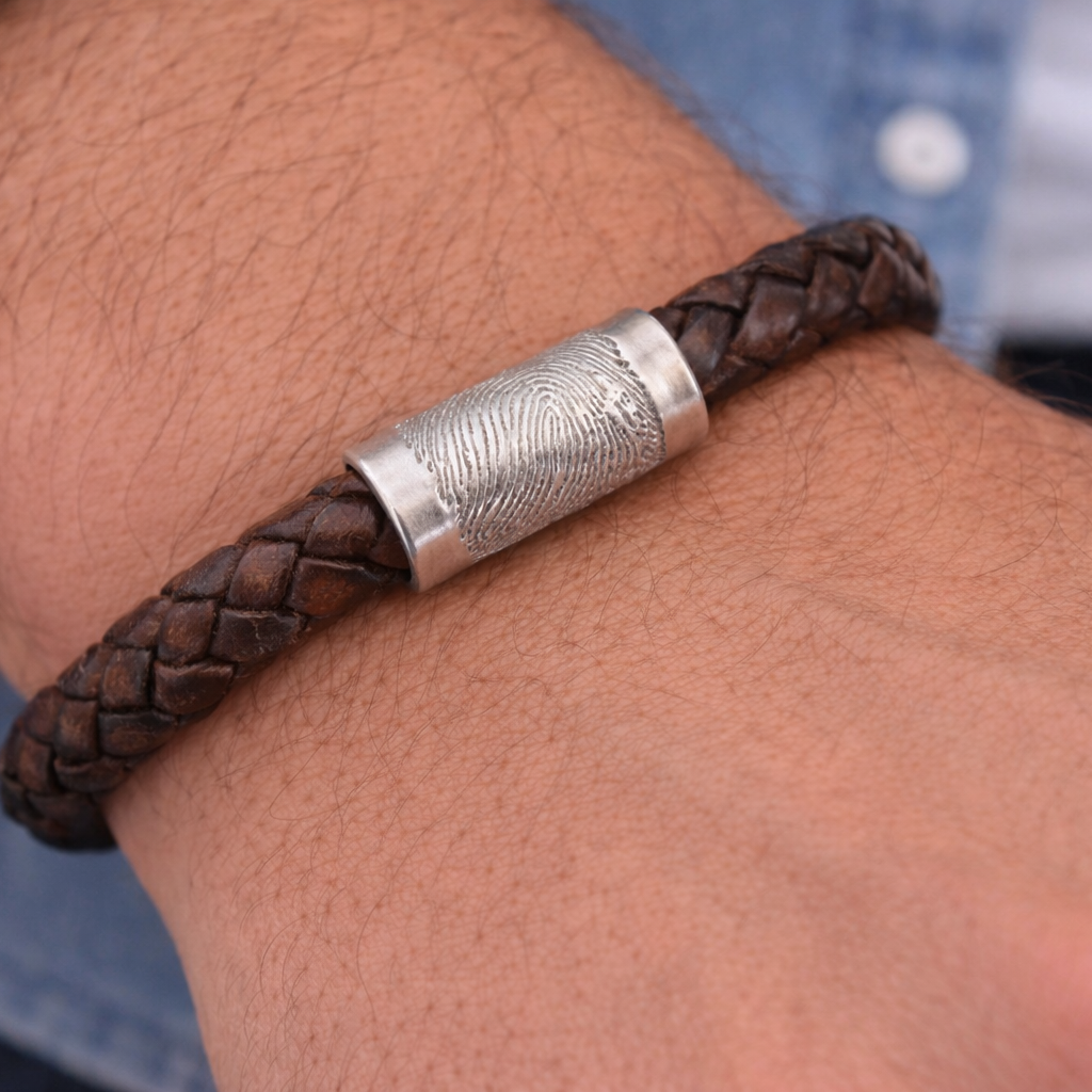 man wearing brown leather bracelet with a fingerprint charm