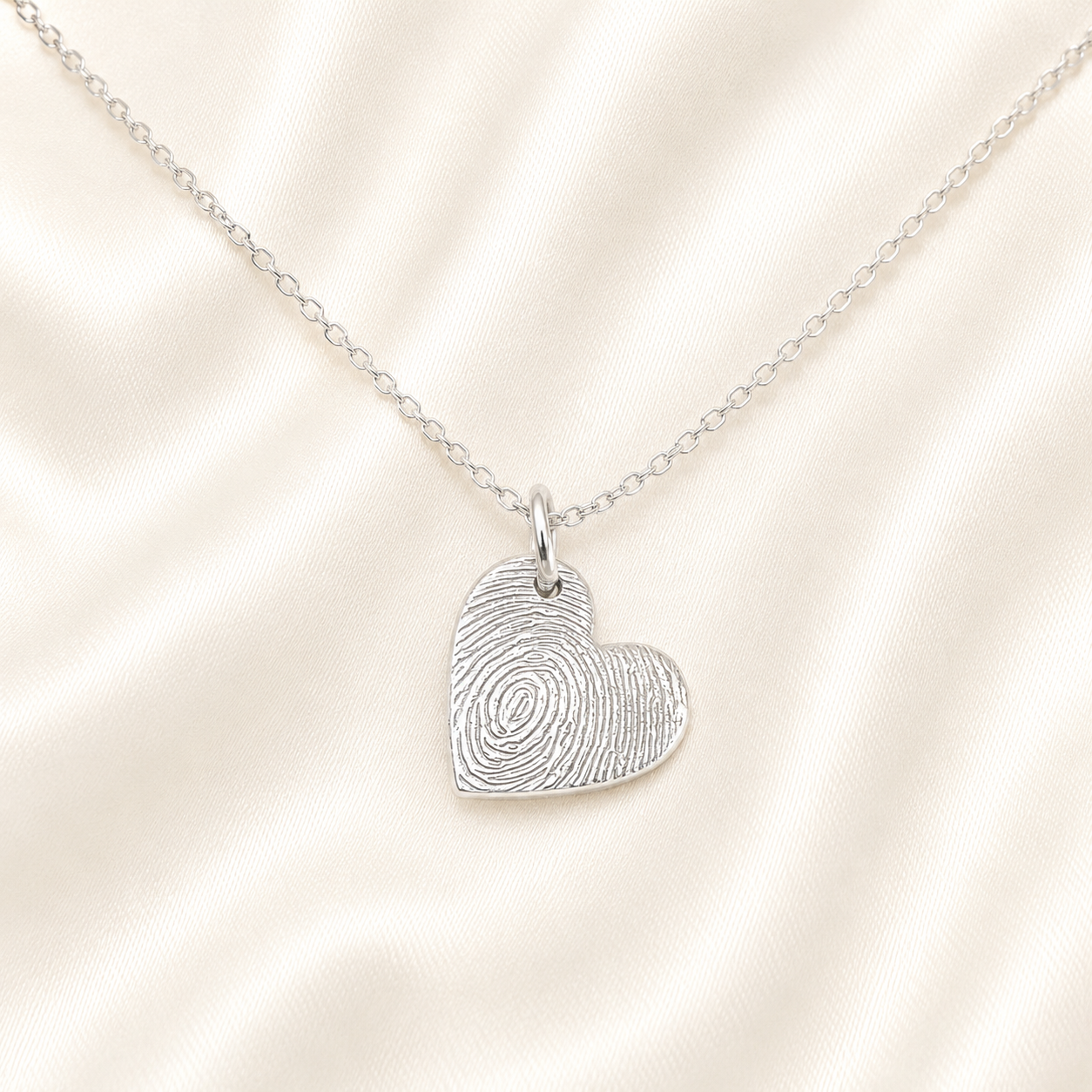 Small silver heart with fingeprint on it