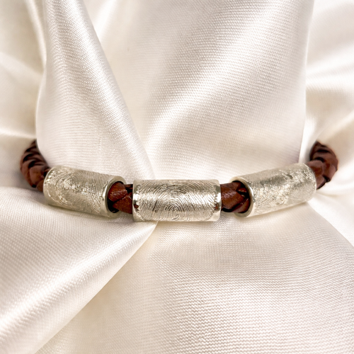 3 fingerprint charms on a leather bracelet